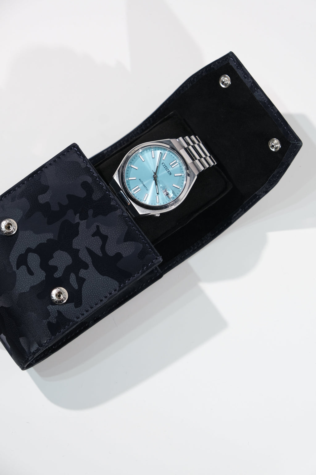 Silver watch with blue face in a black camouflage-patterned case on a white background